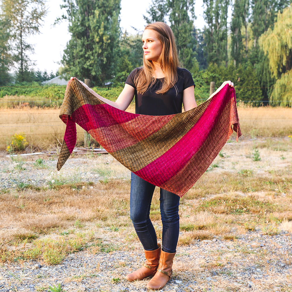 A woman holding a textured shawl.